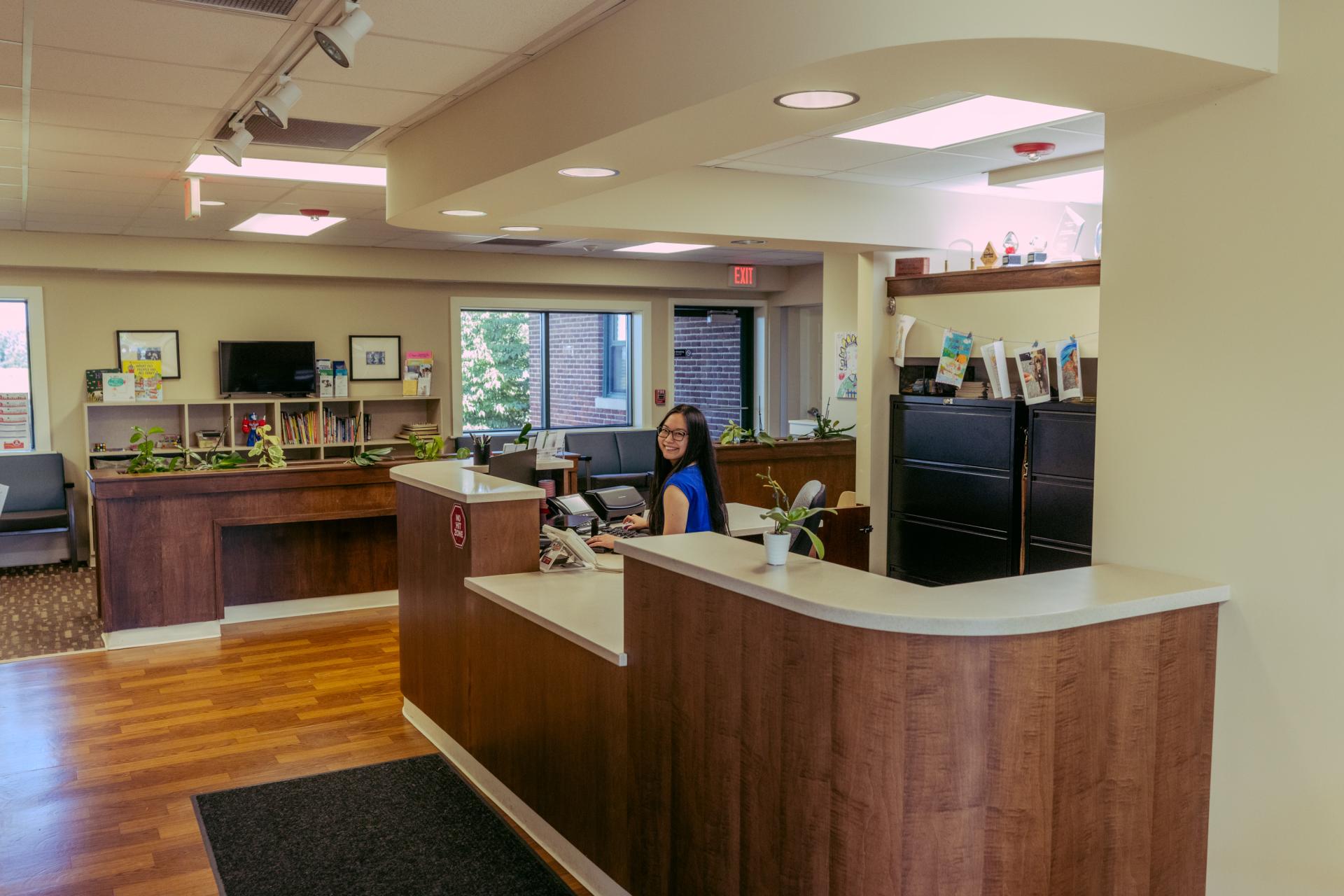 front desk of CAC building with receptionist smiling