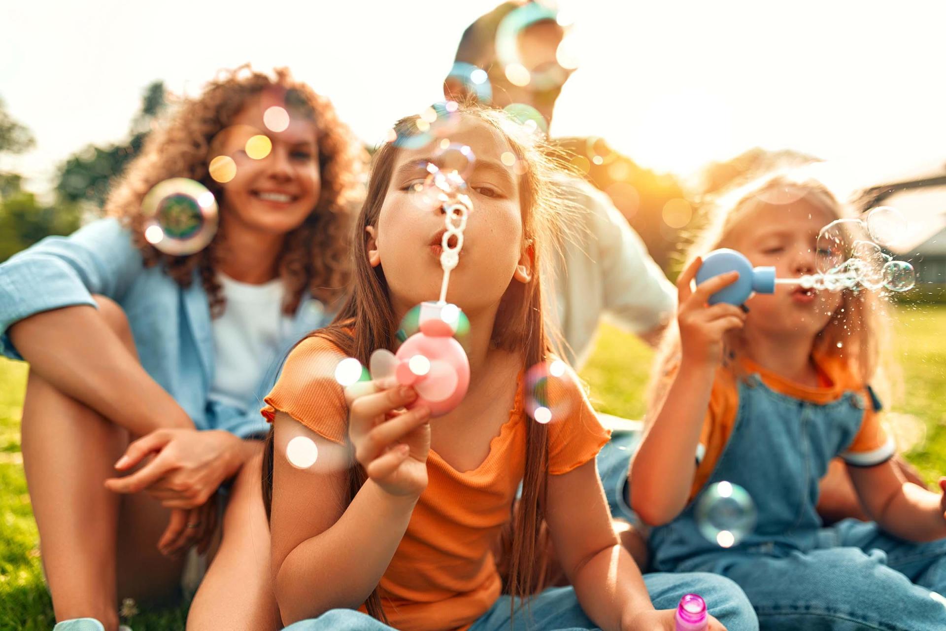 Children blowing bubbles together on a warm summer day.